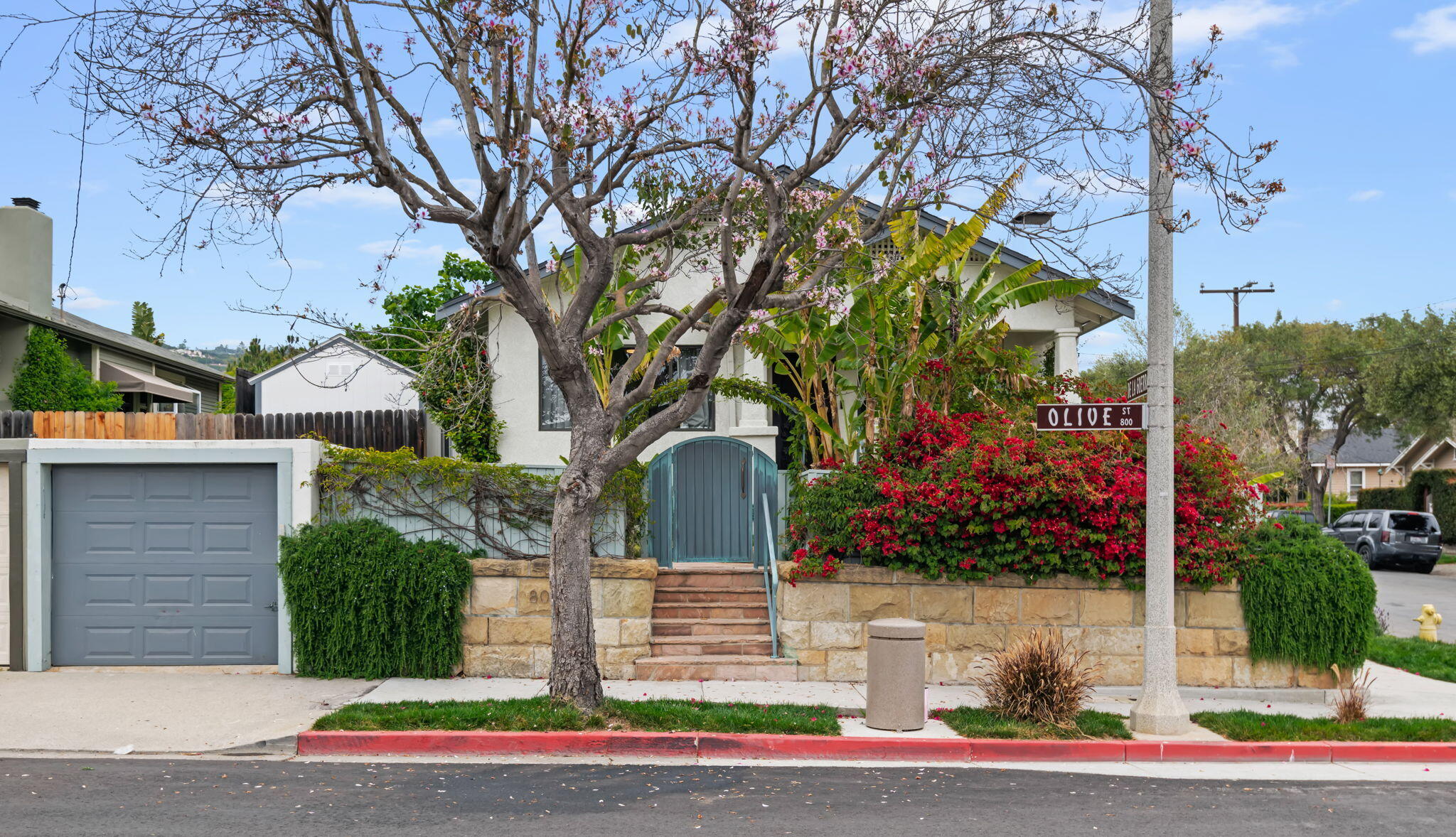 a front view of a house with a yard and potted plants
