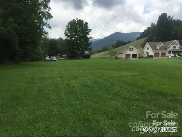 a view of a green field with mountains in the background
