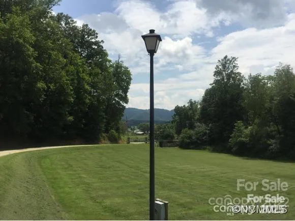 a backyard of a house with lots of green space and lake view