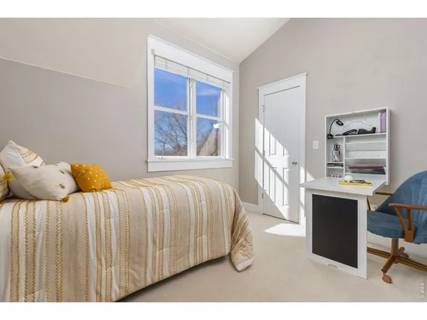 a bedroom with a bed a table and a window