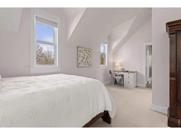 a spacious bedroom with a bed a couch and a window