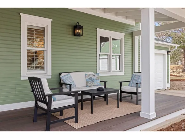 a patio with table and chairs and potted plants