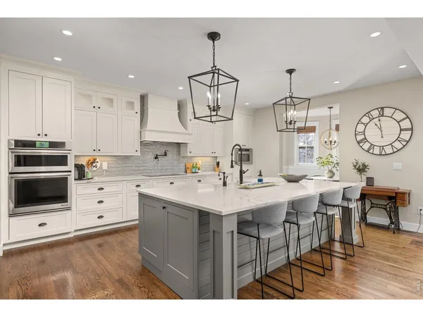 a kitchen with stainless steel appliances kitchen island granite countertop a sink a stove a dining table and chairs