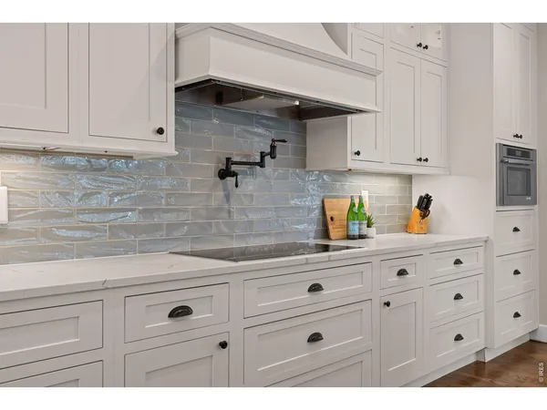 a kitchen with white cabinets and sink