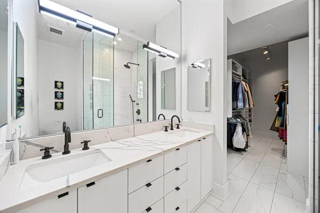 a bathroom with double vanity sinks and a mirror