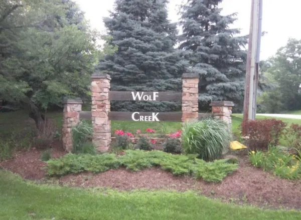 a sign board with plants and trees
