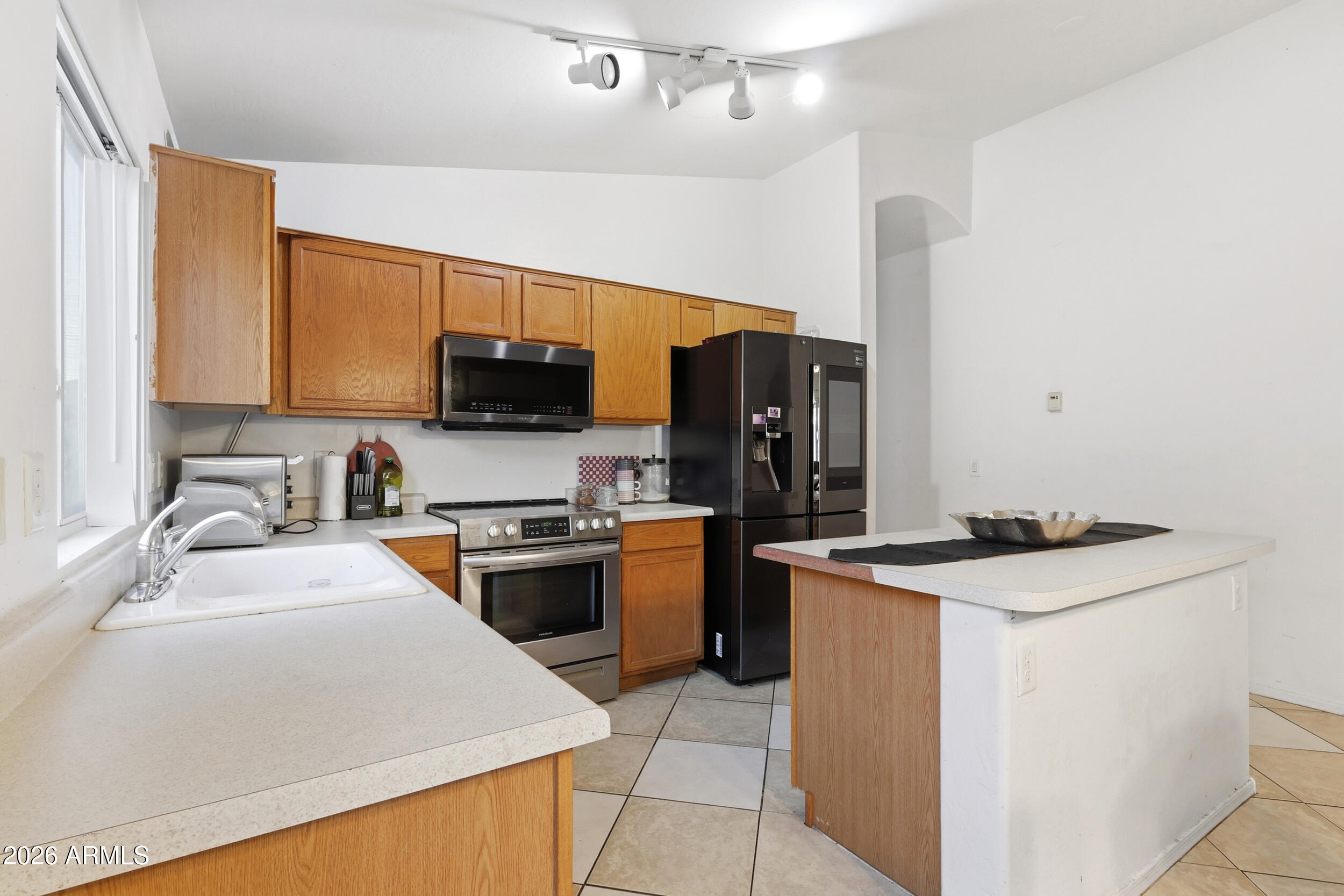 11964 West Granada Road Avondale, AZ 85392 - Photo 12 of 36 a kitchen with a stove top oven sink and refrigerator