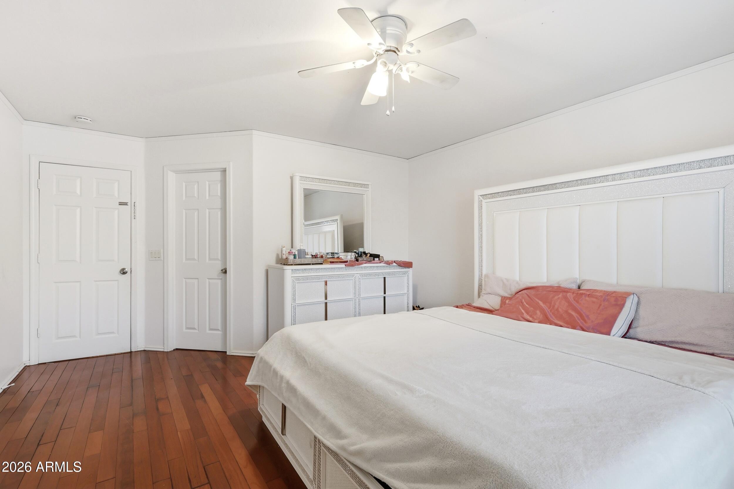 11964 West Granada Road Avondale, AZ 85392 - Photo 19 of 36 a bedroom with a large bed and a chandelier