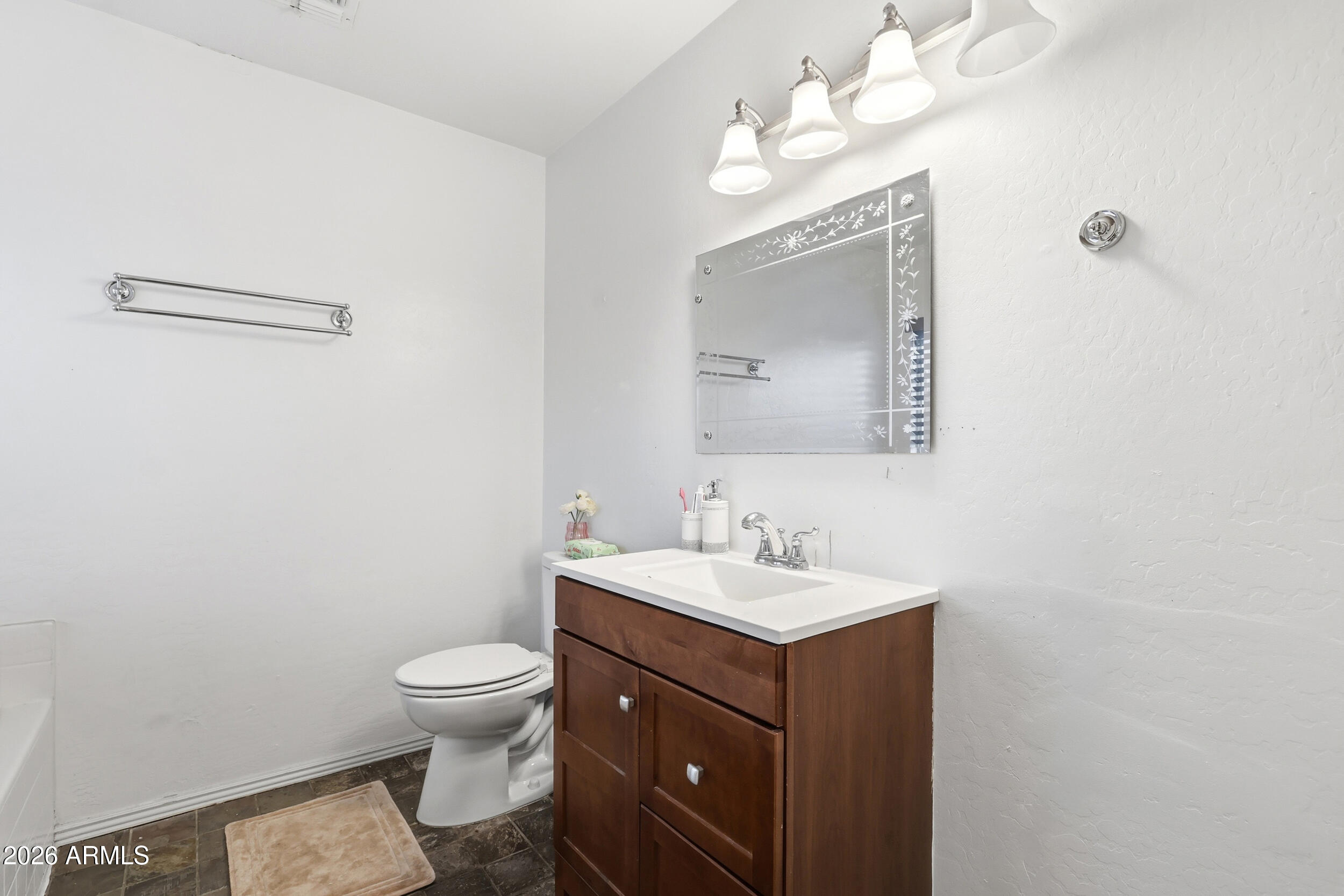 11964 West Granada Road Avondale, AZ 85392 - Photo 21 of 36 a bathroom with a toilet sink and mirror