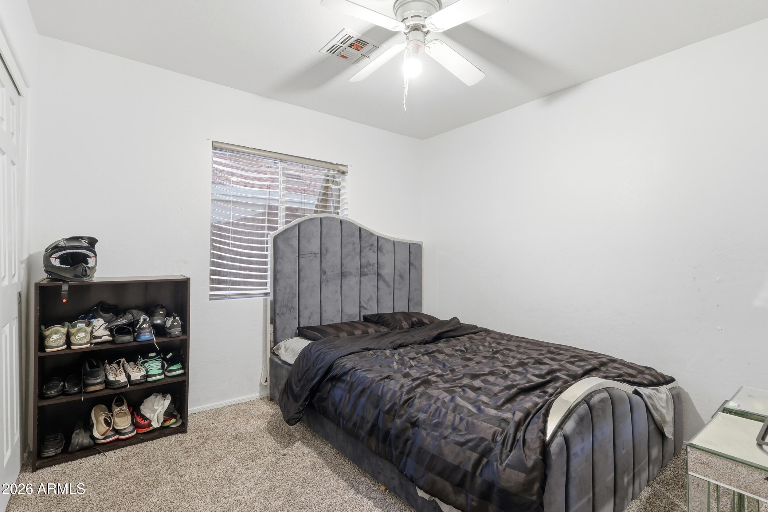 11964 West Granada Road Avondale, AZ 85392 - Photo 24 of 36 a bedroom with a bed and a closet