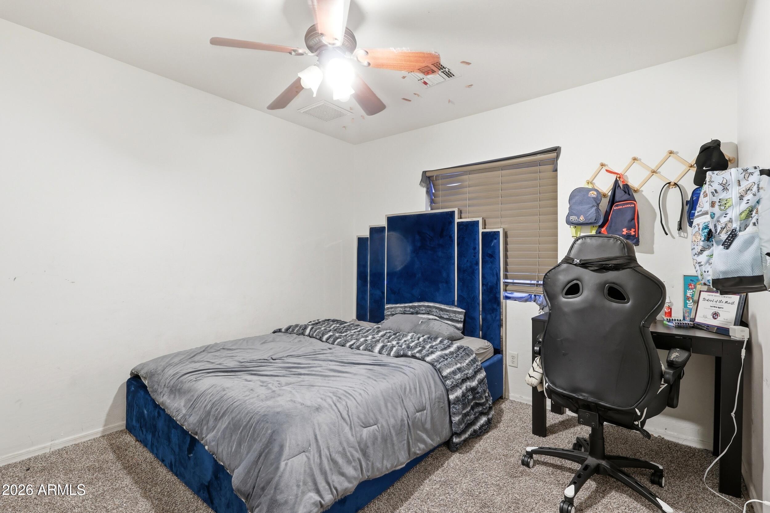 11964 West Granada Road Avondale, AZ 85392 - Photo 27 of 36 a bedroom with a bed and a chandelier