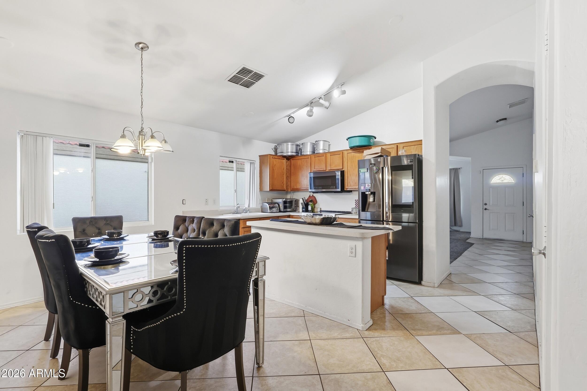 11964 West Granada Road Avondale, AZ 85392 - Photo 9 of 36 a kitchen with a dining table cabinets and appliances