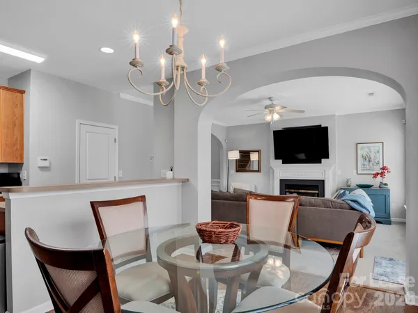 a living room with furniture a flat screen tv and kitchen view