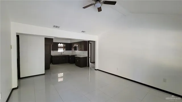 an empty room with a window and a ceiling fan