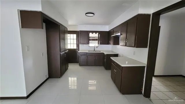 a kitchen with a sink dishwasher a refrigerator and wooden floor