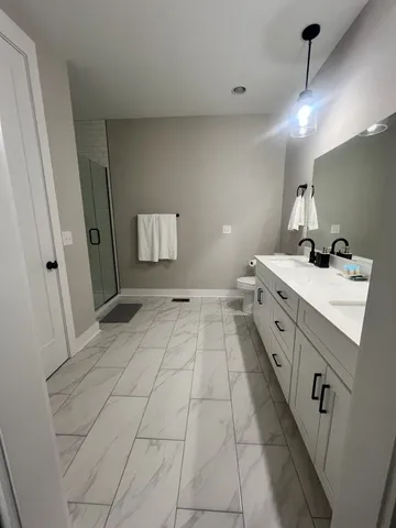 a bathroom with a sink a toilet and mirror