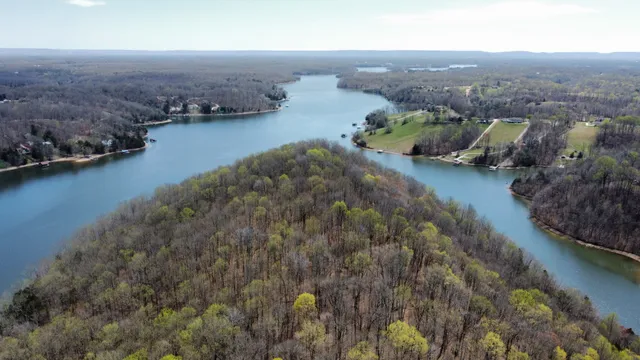 an aerial view of lake residential house with outdoor space and trees around