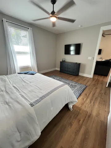 a bedroom with a large bed and a flat tv screen