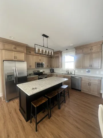 a kitchen with kitchen island a sink stove and refrigerator