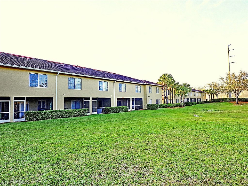 9419 Ivy Brook Run, Unit 1204 Fort Myers, FL 33913 - Photo 17 of 22 a view of a house with a big yard and large trees