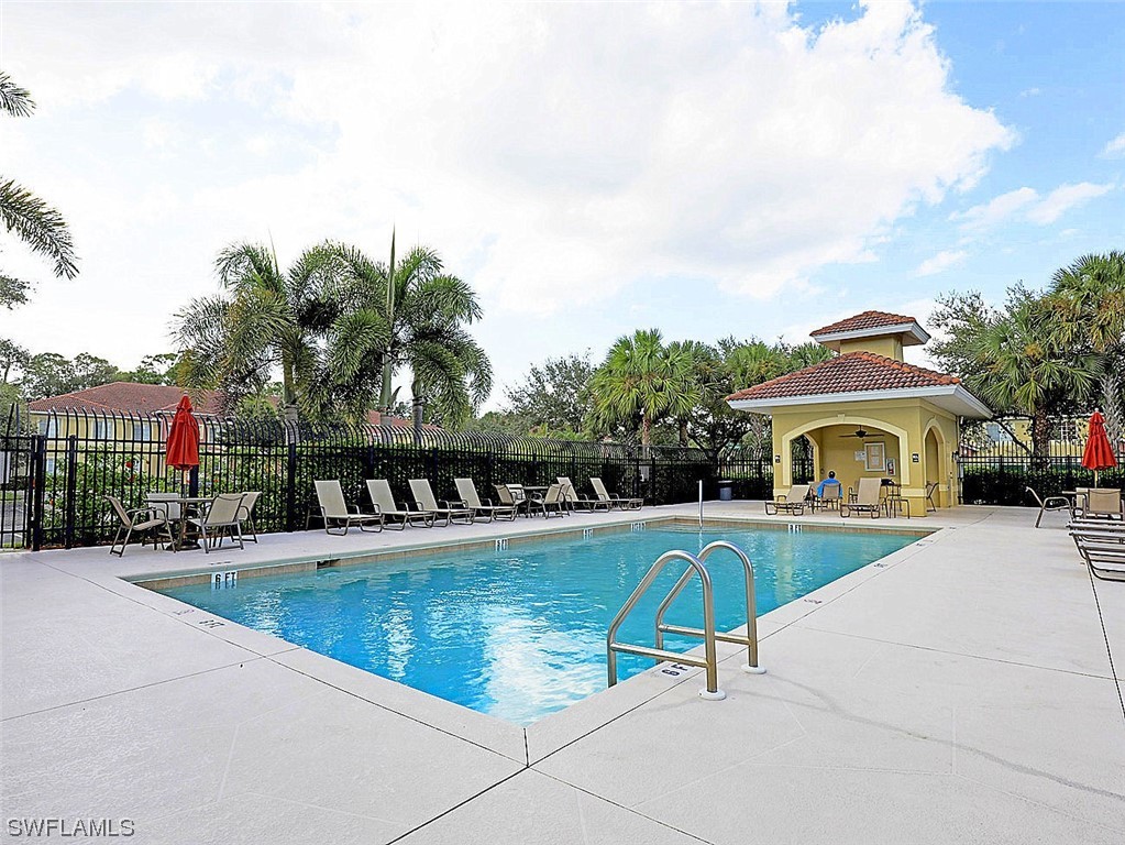 9419 Ivy Brook Run, Unit 1204 Fort Myers, FL 33913 - Photo 19 of 22 a view of swimming pool with a garden and trees