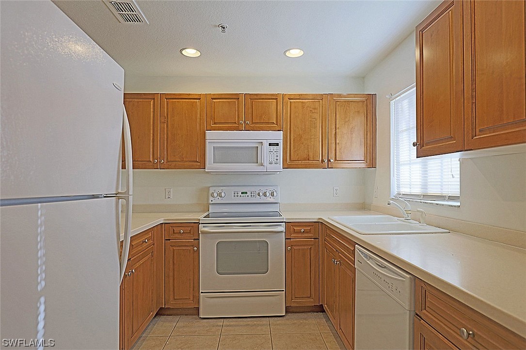 9419 Ivy Brook Run, Unit 1204 Fort Myers, FL 33913 - Photo 3 of 22 a kitchen with a stove sink and cabinets