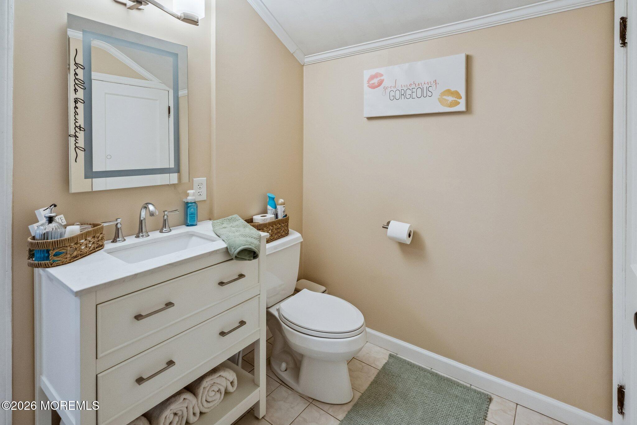 121 Corson Avenue Hamilton, NJ 08619 - Photo 27 of 32 a bathroom with a granite countertop toilet a sink and a mirror