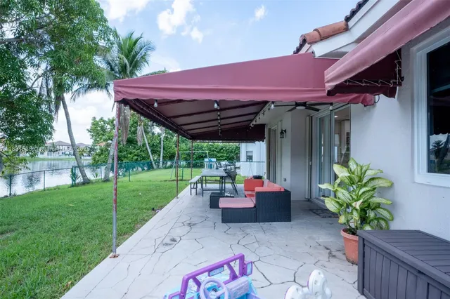 a view of a backyard with table and chairs potted plants