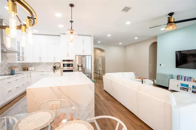 a large room with kitchen island a flat screen tv and a view of living room