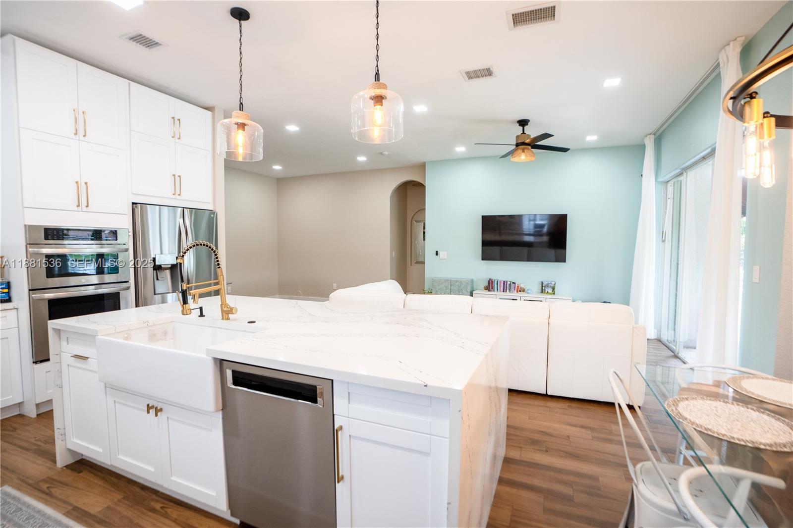 13000 Southwest 52nd Street Miramar, FL 33027 - Photo 7 of 16 a large white kitchen with a large counter top space stainless steel appliances and a chandelier