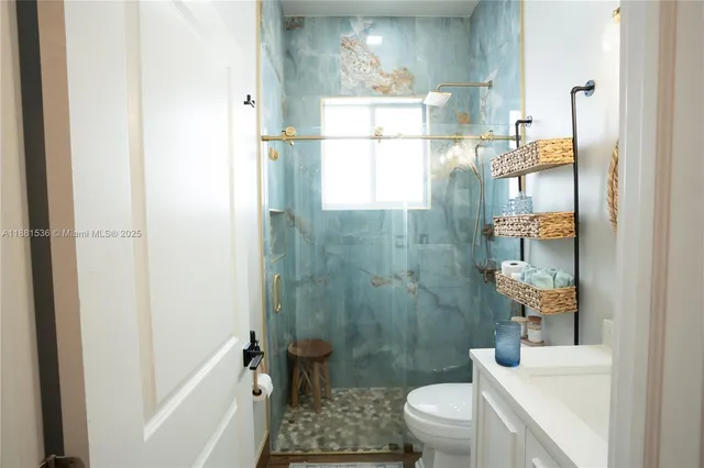 a bathroom with a sink a toilet and shower