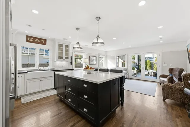 a kitchen with counter top space sink stove and wooden floor