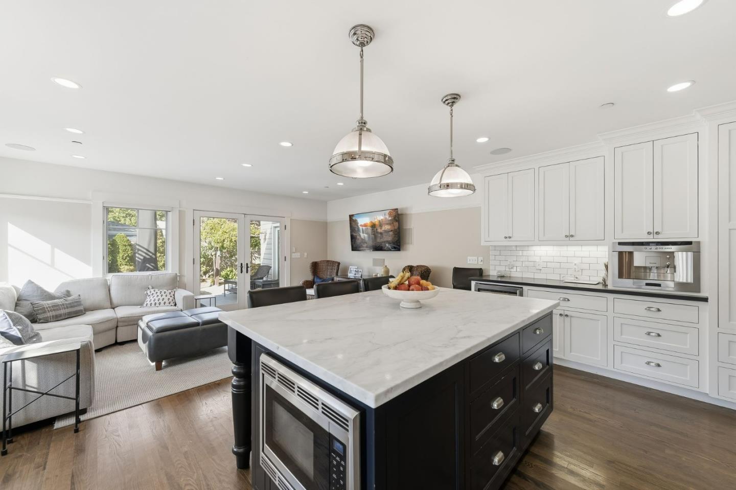 1212 Mills Avenue Burlingame, CA 94010 - Photo 7 of 32 a kitchen with a stove a sink a kitchen island with wooden cabinets and wooden floor