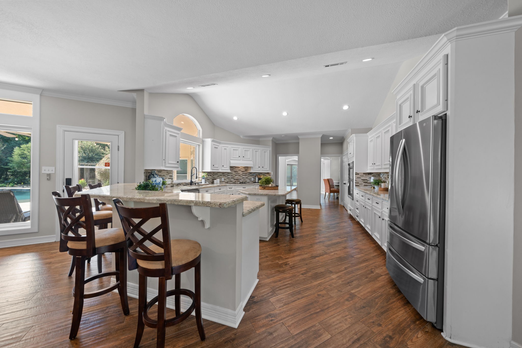 18355 Burkhardt Road Tomball, TX 77377 - Photo 6 of 50 a kitchen with stainless steel appliances a dining table chairs and wooden floor