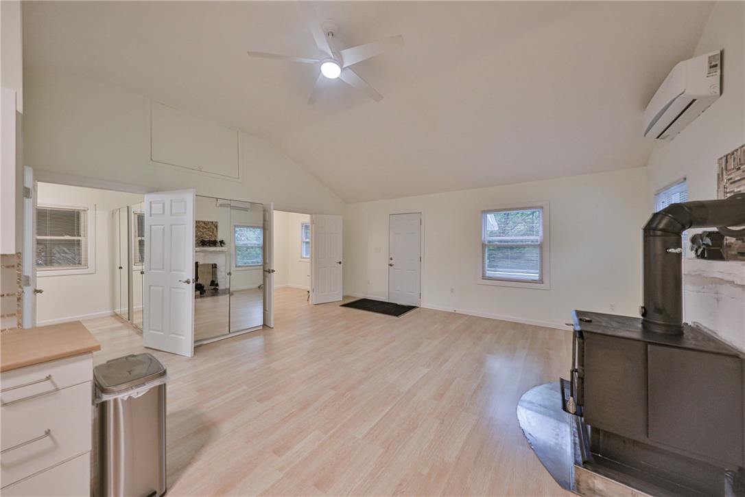 5599 Minks Pond Road Bushkill, PA 18324 - Photo 11 of 64 An airy great room features vaulted ceilings, light-toned hardwood flooring, and a corner wood stove.