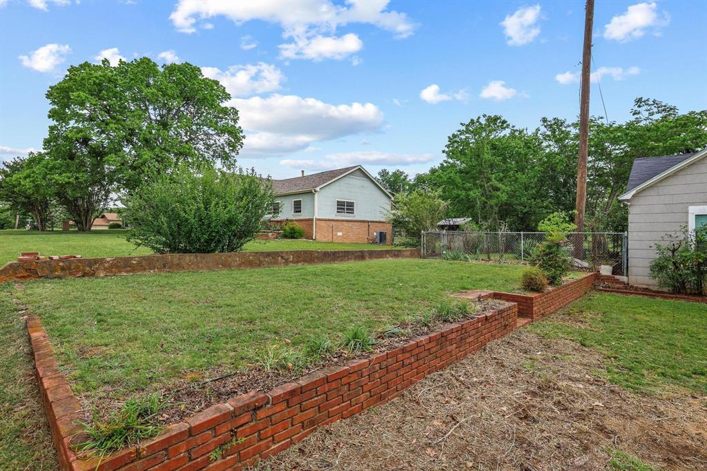 1107 West Hull Street Denison, TX 75020 - Photo 4 of 27 a front view of a house with garden