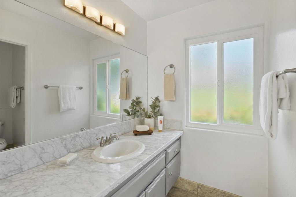 1126 Hermosillo Glen Escondido, CA 92026 - Photo 18 of 32 a bathroom with a granite countertop sink and a mirror