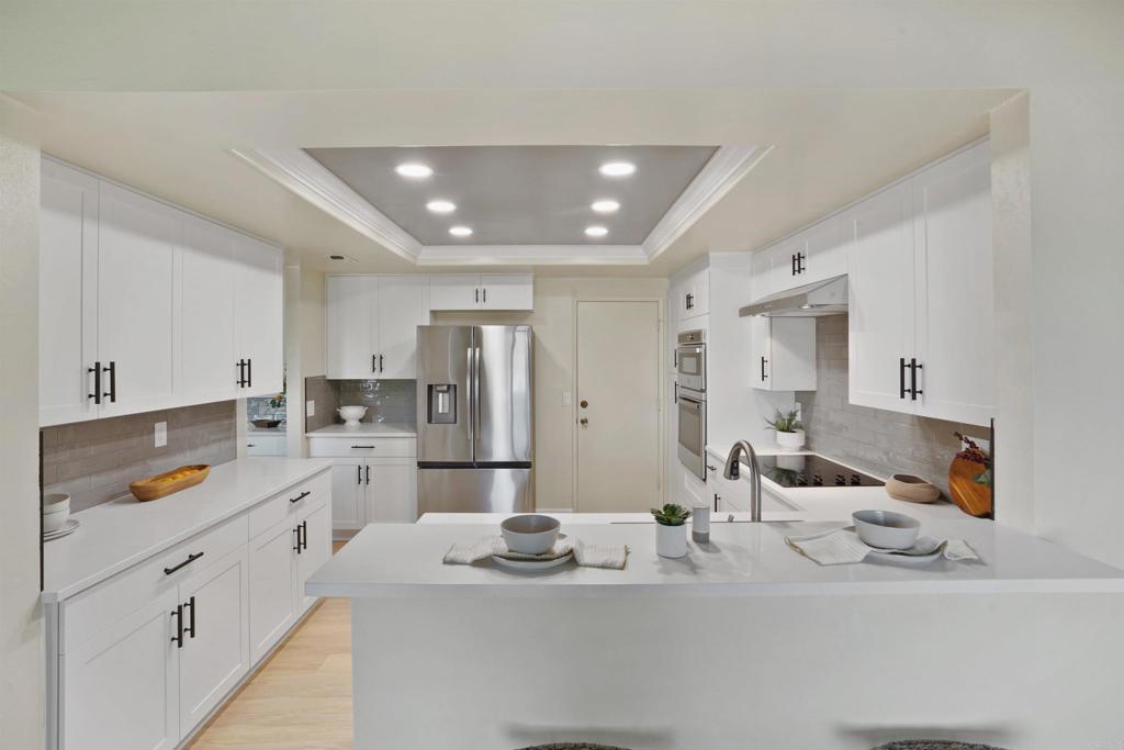 1126 Hermosillo Glen Escondido, CA 92026 - Photo 9 of 32 a kitchen with stainless steel appliances kitchen island granite countertop a sink and cabinets