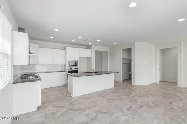 a kitchen with stainless steel appliances kitchen island sink refrigerator and cabinets