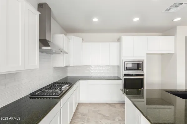 a kitchen with stainless steel appliances granite countertop a stove a sink and a refrigerator
