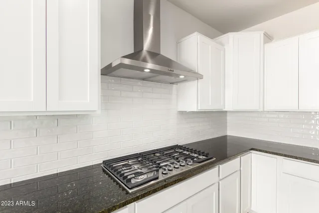 a kitchen with a stove and a white cabinet