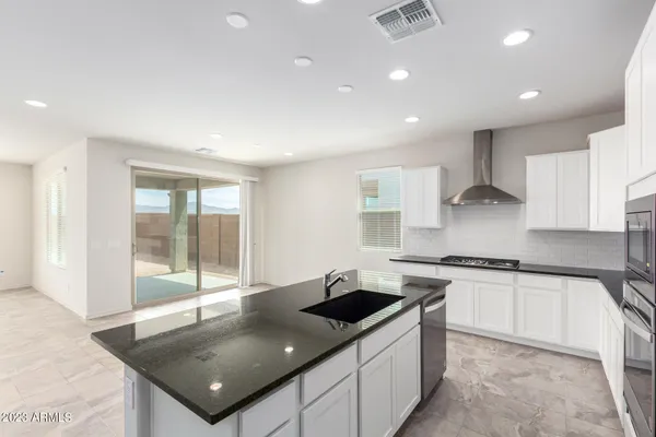 a kitchen with stainless steel appliances granite countertop a sink a stove and a refrigerator