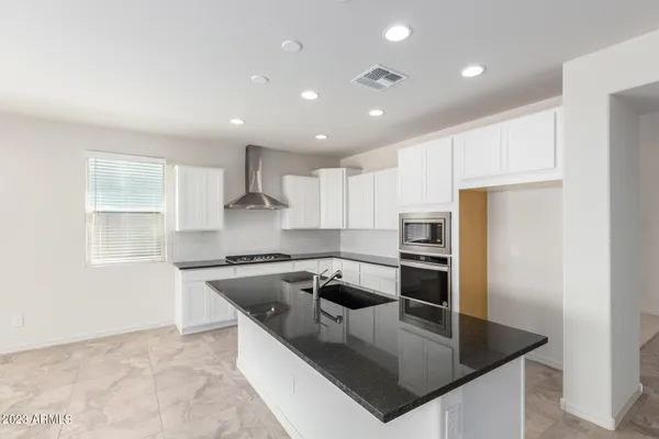 a kitchen with stainless steel appliances granite countertop a sink a stove and a refrigerator