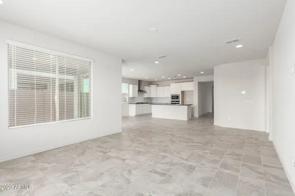 a view of open kitchen with white cabinets and a window