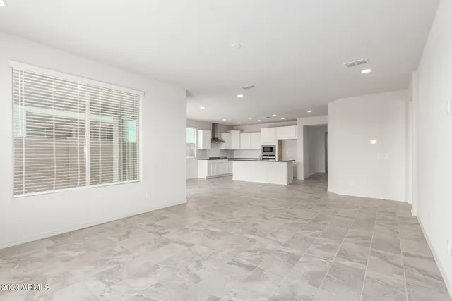 a view of open kitchen with white cabinets and a window