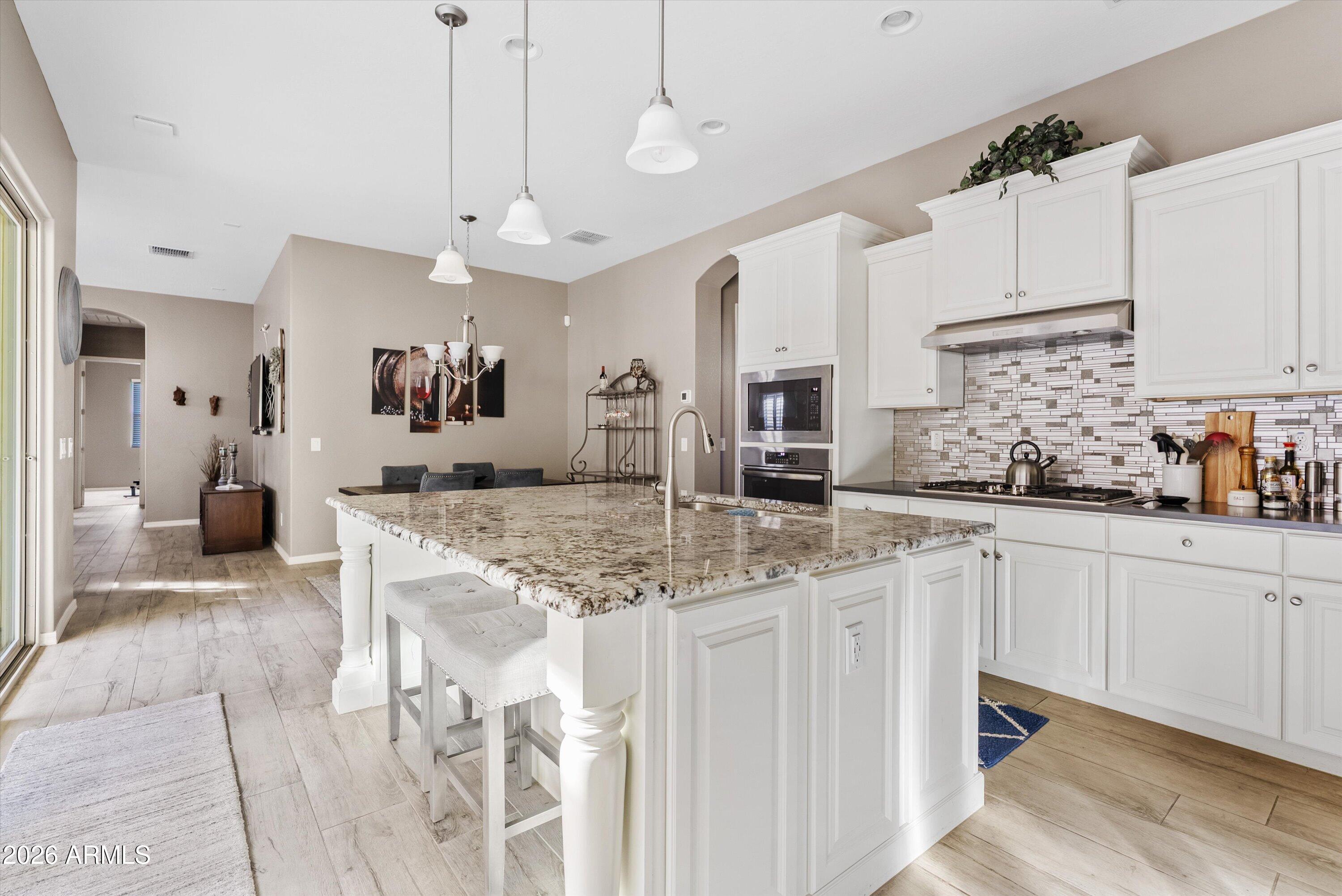 4461 East Jones Street Gilbert, AZ 85295 - Photo 11 of 40 a kitchen with stainless steel appliances granite countertop a sink and cabinets