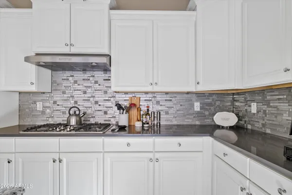a kitchen with white cabinets and sink