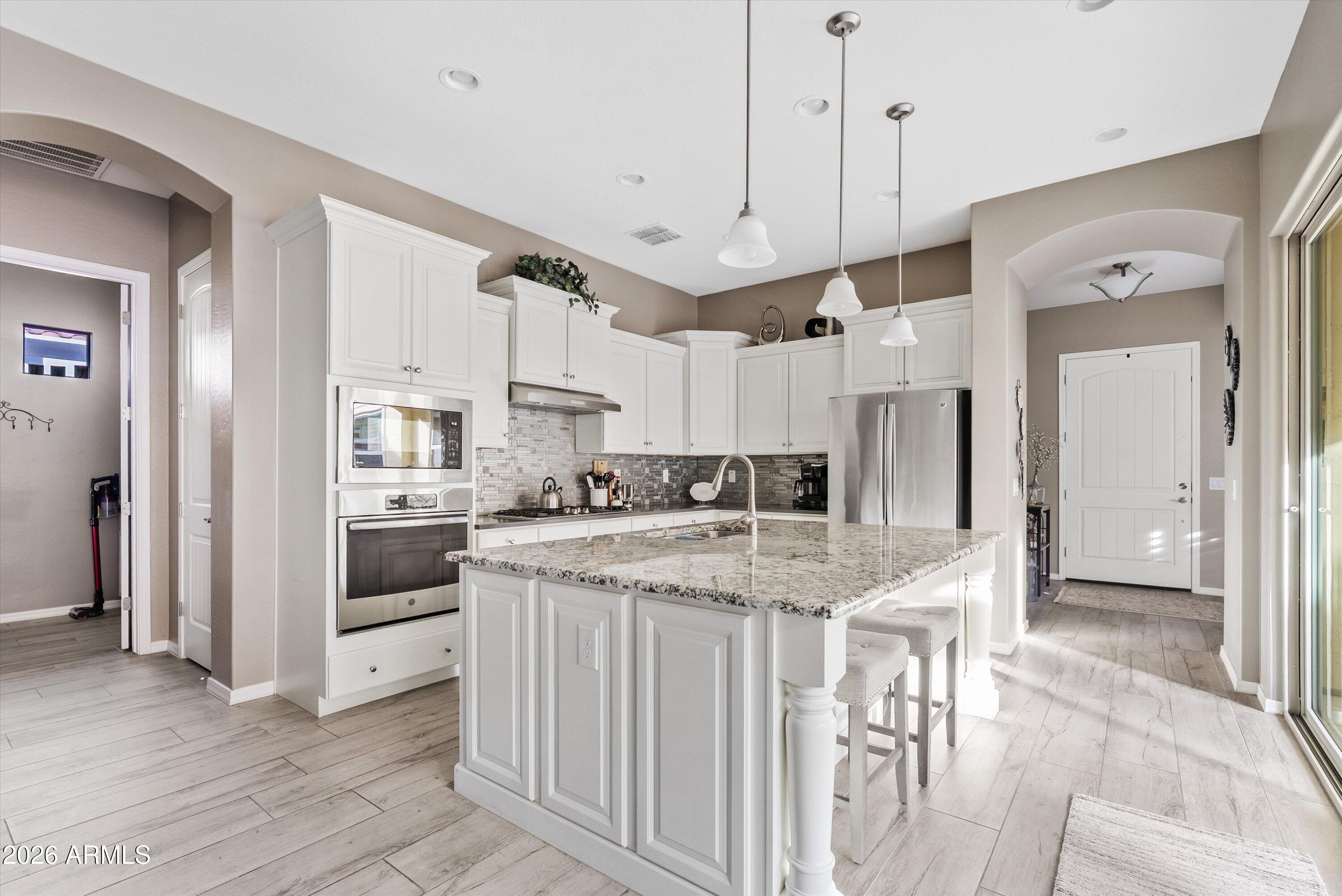 4461 East Jones Street Gilbert, AZ 85295 - Photo 13 of 40 a kitchen with a stove a refrigerator and a dining table