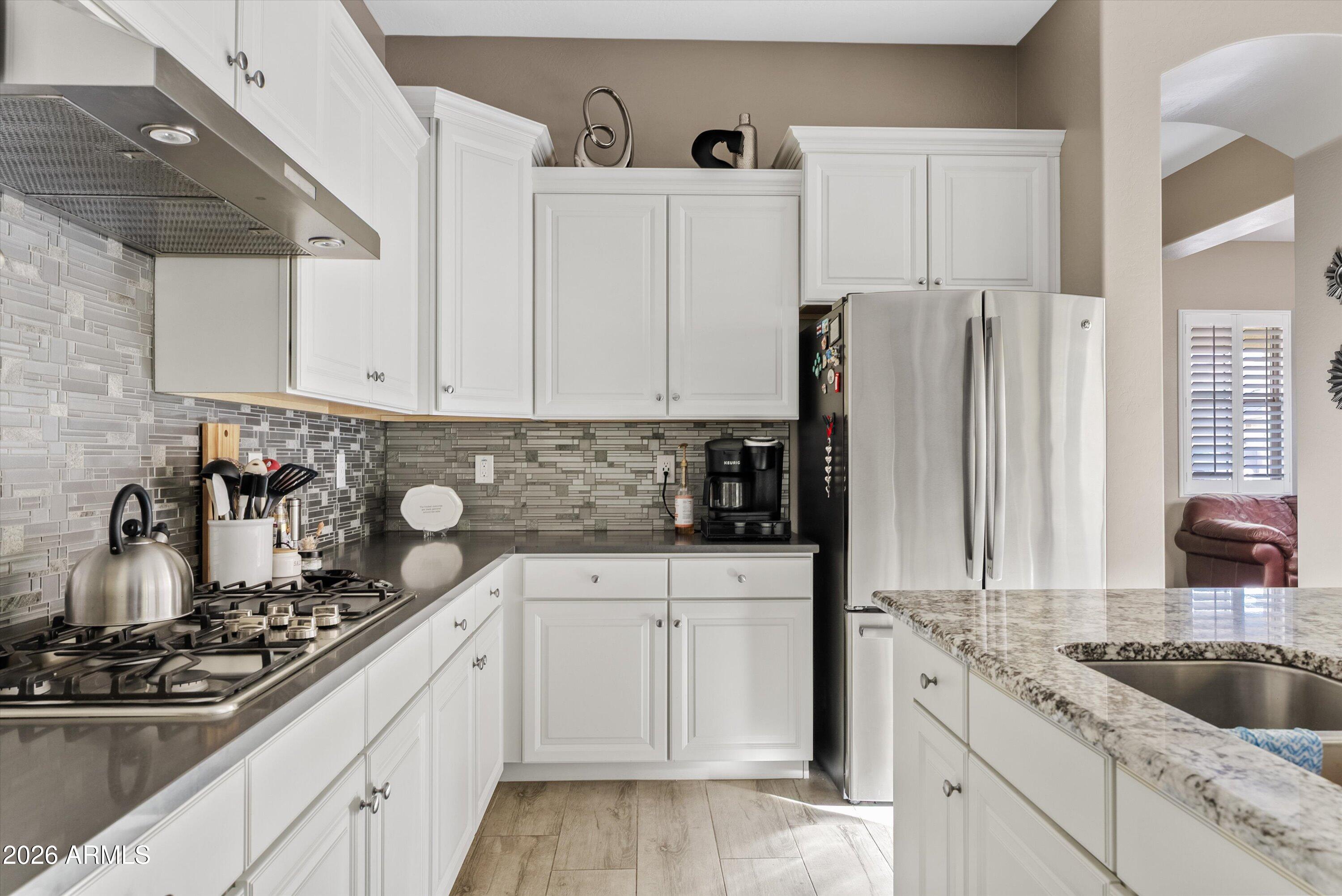 4461 East Jones Street Gilbert, AZ 85295 - Photo 14 of 40 a kitchen with white cabinets sink and stainless steel appliances