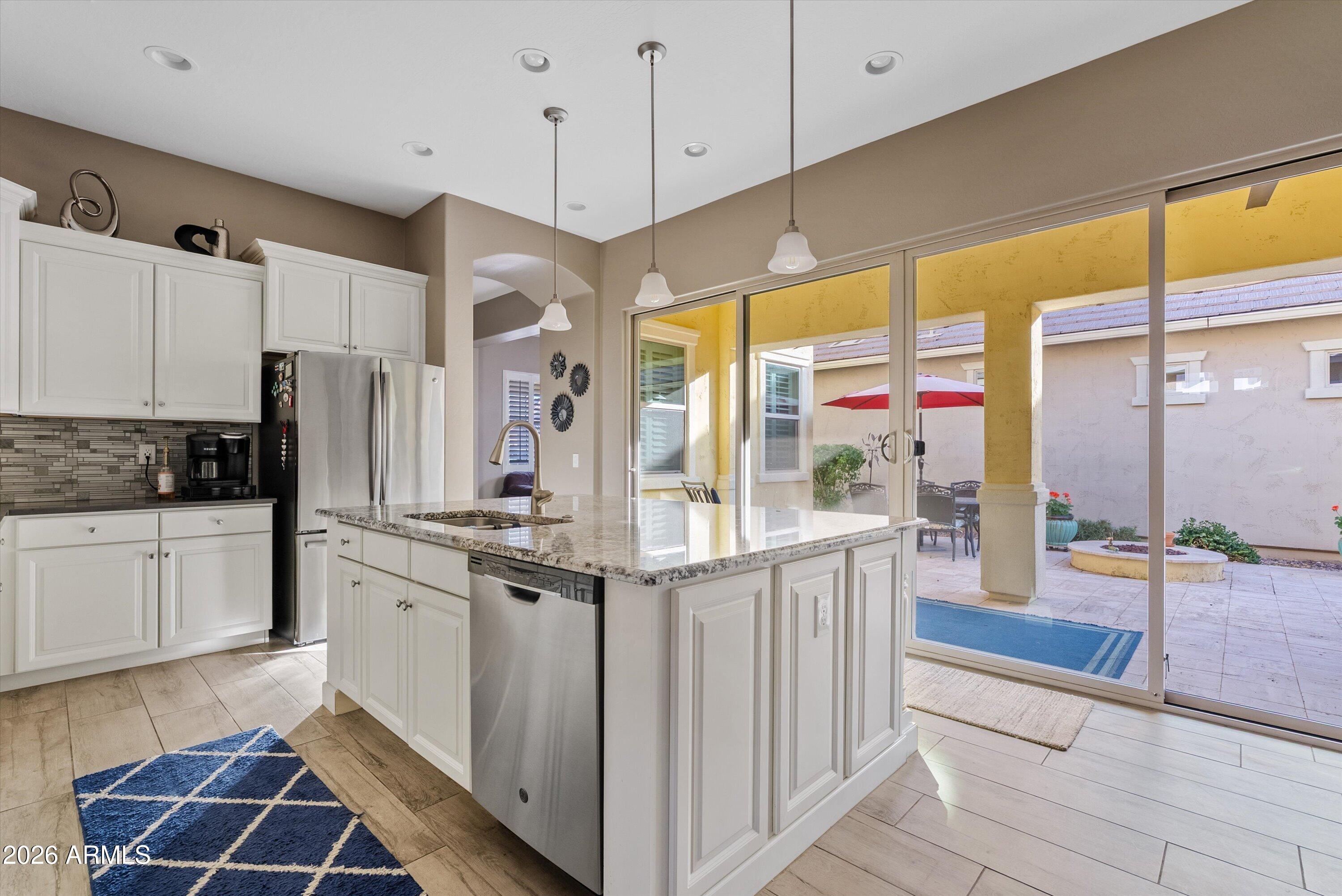 4461 East Jones Street Gilbert, AZ 85295 - Photo 15 of 40 a kitchen with stainless steel appliances granite countertop a stove and a refrigerator